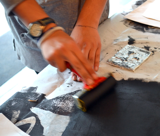 Preparing the roller by rolling and working a thin layer of ink onto acetate