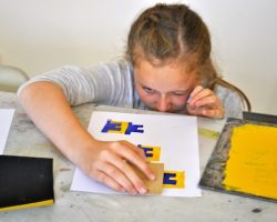 Working with artist Andy McKenzie to create repeat patterns of letters using block printing.