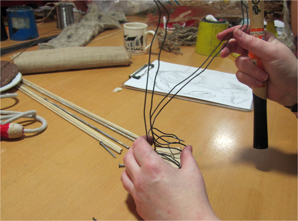 Attaching modelling wire with nail to wooden block to make an armature