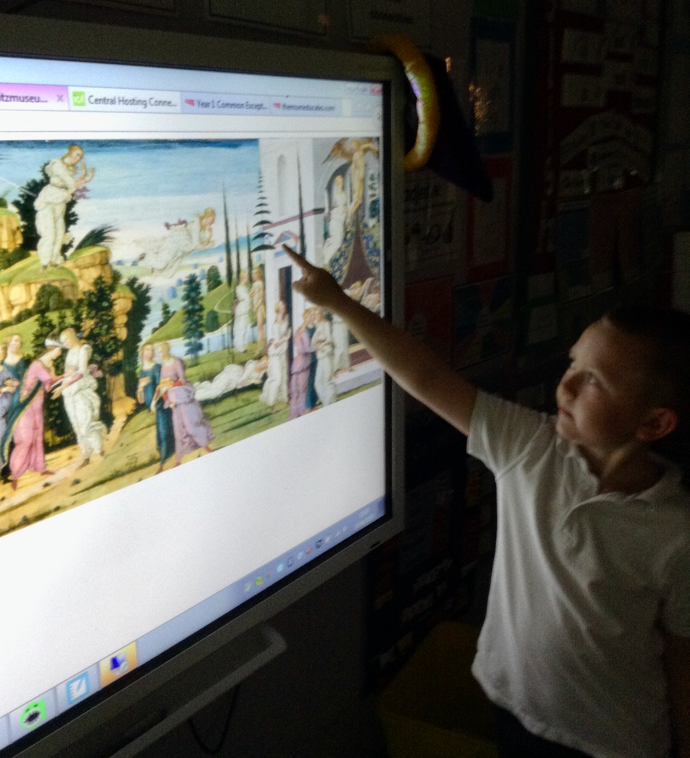 A boy looking at a painting of Cupid and Psyche on a whiteboard in a classroom