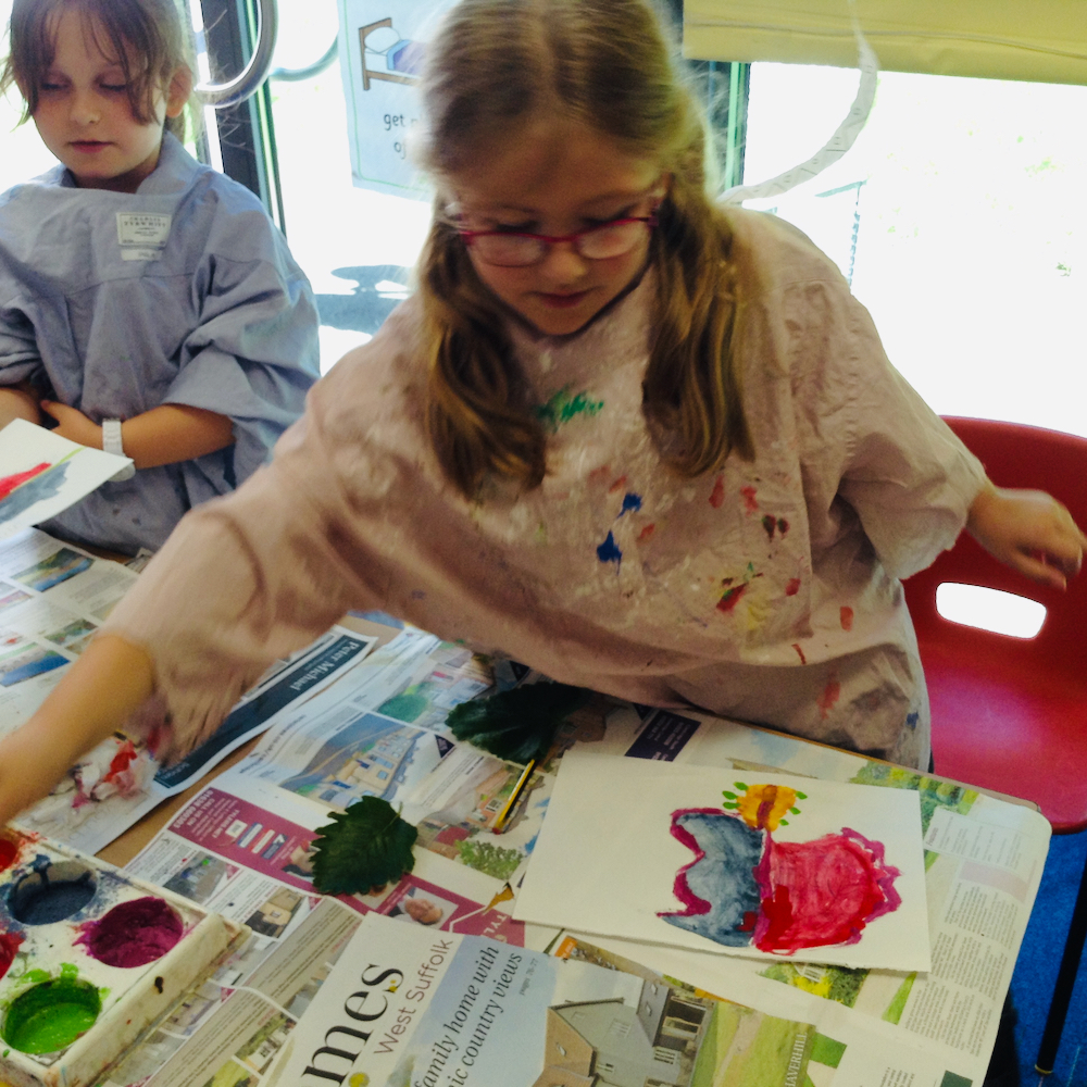 Girl paints a colourful leaf with egg tempera mixing powder paint and egg at Hauxton Primary for Inspire with Pamela Stewart 