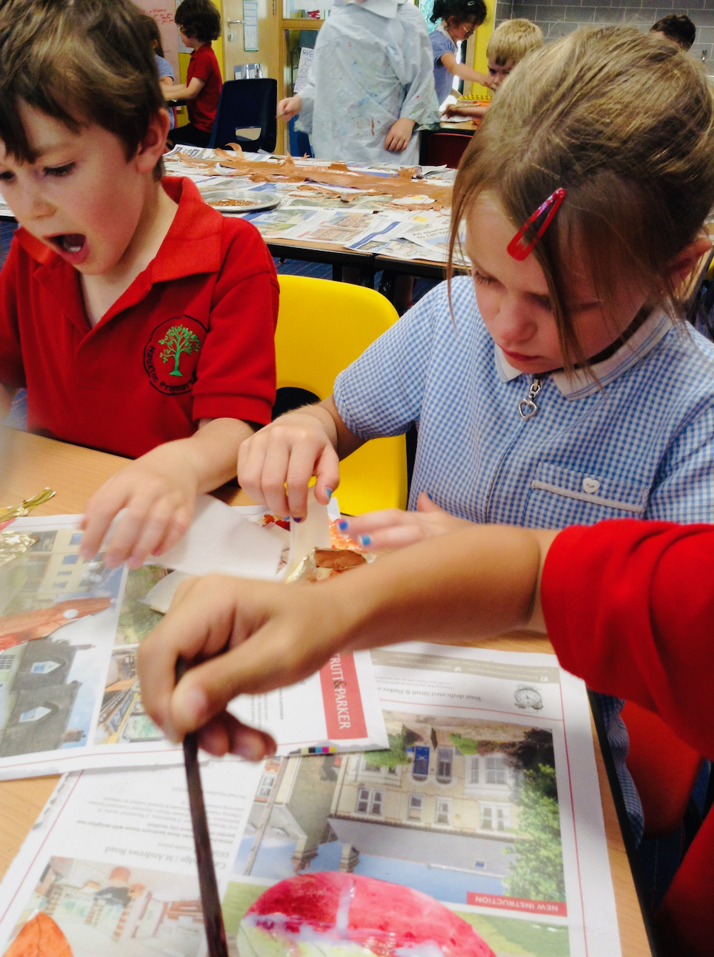 Children apply gold leaf to gild their painted leaves at Hauxton Primary School with Pamela Stewart for Inspire