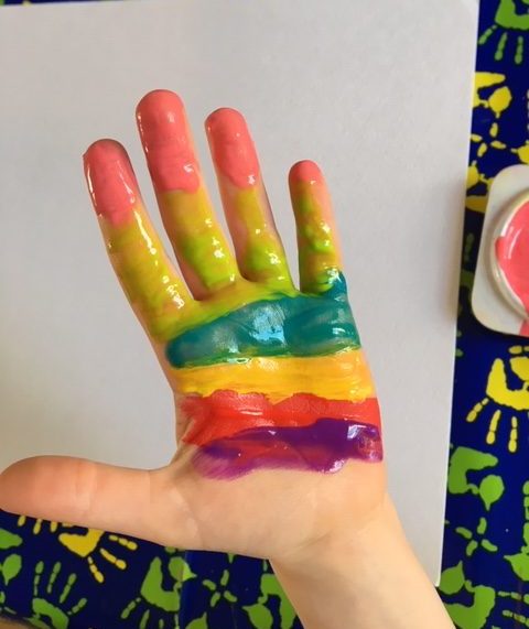 cover the hand with stripes of rainbow colour