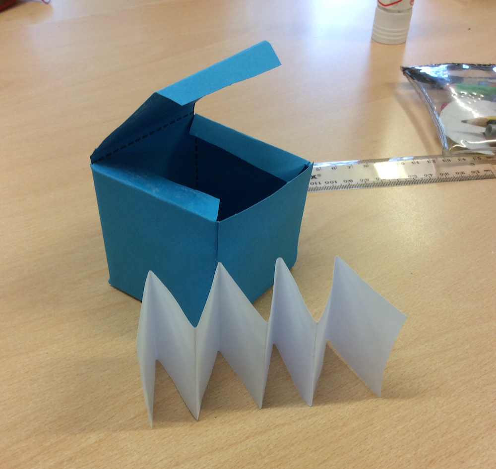A folded cube and concertina folded paper